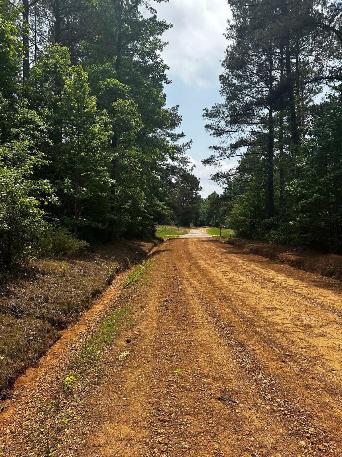 Gravel county road along wooded tracts for sale in Attala County